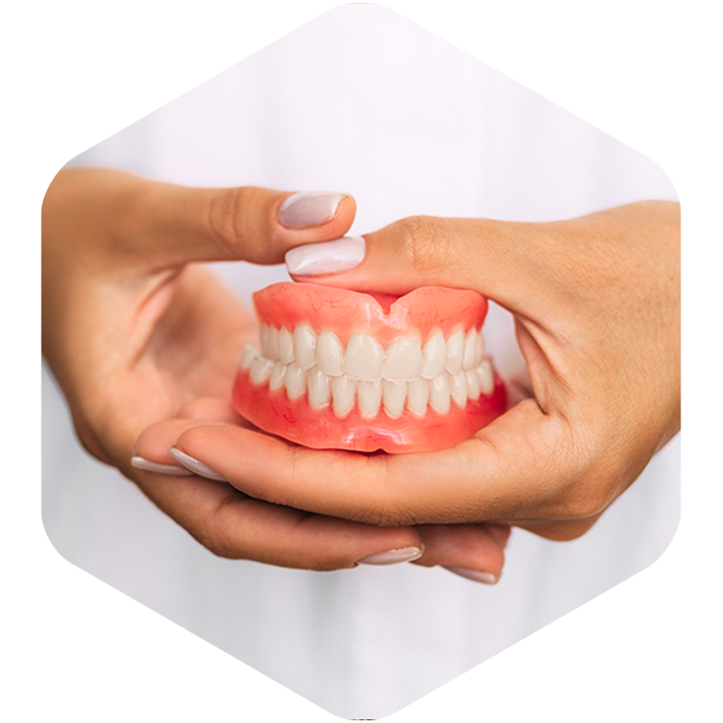 Dentist holding dentures for fitting